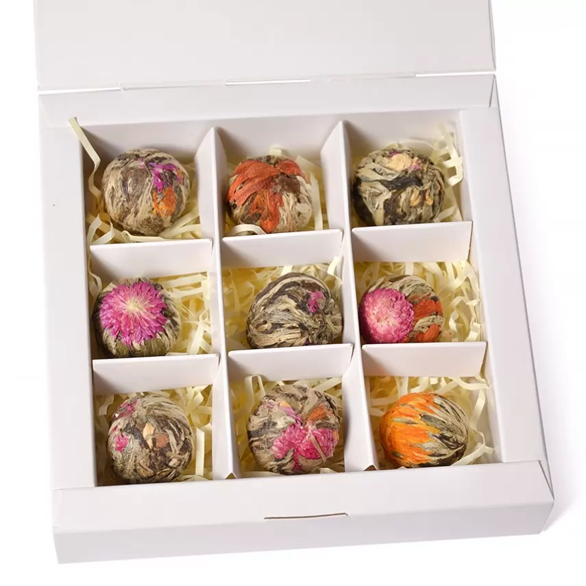 Small kraft gift box with four flowering tea balls including a pink bloom
